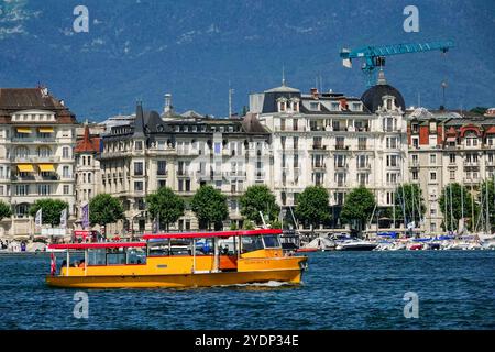 Un bateau-navette jaune appelé a Mouettes passe le côté est sur le lac Léman, Genève, Suisse. Banque D'Images