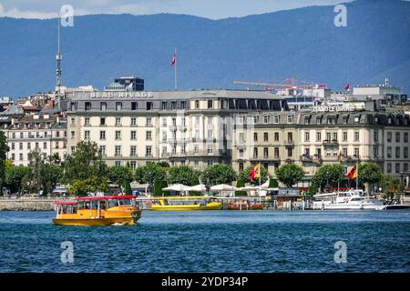 Un bateau-navette jaune appelé a Mouettes passe le côté est sur le lac Léman, Genève, Suisse. Banque D'Images