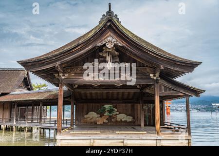 Hiroshima, Japon - 20 août 2024 : scène flottante de No Theatre et vue de la porte Otorii au sanctuaire shinto Itsukushima Jinja. Situé sur l'île de Miyajima Banque D'Images