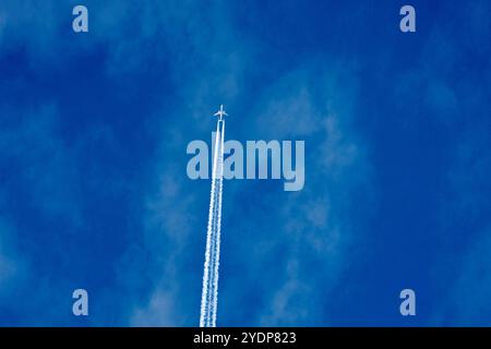 Bavière, Allemagne - 27 octobre 2024 : avion avec des traînées dans le ciel bleu clair, souvent partie des théories du complot sur les produits chimiques dans l'atmosphère *** Flugzeug mit Kondensstreifen am klaren blauen Himmel, oft Teil von Verschwörungstheorien über Chemikalien in der Atmosphäre Banque D'Images