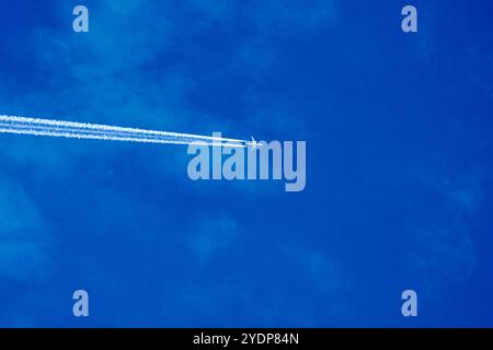 Bavière, Allemagne - 27 octobre 2024 : avion avec des traînées dans le ciel bleu clair, souvent partie des théories du complot sur les produits chimiques dans l'atmosphère *** Flugzeug mit Kondensstreifen am klaren blauen Himmel, oft Teil von Verschwörungstheorien über Chemikalien in der Atmosphäre Banque D'Images