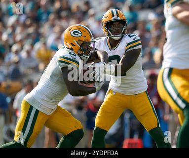 Jacksonville, Floride, États-Unis. 27 octobre 2024. National Football League, Jacksonville Jaguars vs Green Bay Packers. Le quarterback des Packers de Green Bay, Malik Willis (2), en secours pour Jordan Love, remet le ballon au Running back Josh Jacobs (8). Crédit photo : Tim Davis/Alamy Live News Banque D'Images