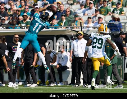 Jacksonville, Floride, États-Unis. 27 octobre 2024. National Football League, Jacksonville Jaguars vs Green Bay Packers. Jacksonville Jaguars Wide Receiver Parker Washington (11 ans) fait une prise bondissante sur la ligne de touche alors qu'il est vaguement gardé par la sécurité des Packers de Green Bay Xavier McKinney (29 ans). Crédit photo : Tim Davis/Alamy Live News Banque D'Images