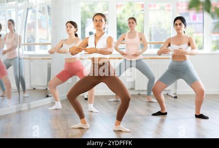 Jeune femme dirigeant une classe de ballet amateur en studio Banque D'Images