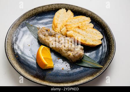 Tartare de fruits de mer gastronomique avec baguette grillée et garniture d'agrumes, offrant saveurs et élégance Banque D'Images