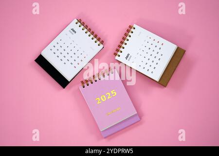 Trois calendriers de bureau de janvier 2025, magnifiquement disposés sur un fond rose vif. Banque D'Images