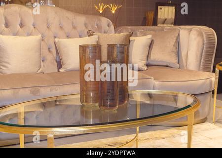 Table basse avec un plateau en verre transparent avec des vases élégants dans une pièce lumineuse. Intérieur Banque D'Images