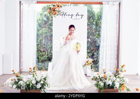 Petit mariage - le prêtre est présent, la mariée et le marié tiennent leurs bouquets de mariage, se tiennent la main et partagent un beau moment avec la famille et les amis Banque D'Images