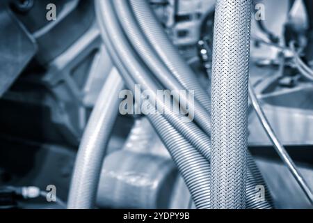 Gros plan du moteur de voiture avec des tubes et des câbles dans des tons bleus Banque D'Images