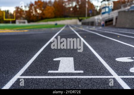 Fermez la voie numéro 1 sur une nouvelle piste de course noire avec des lignes de voie blanches et d'autres marquages. Banque D'Images