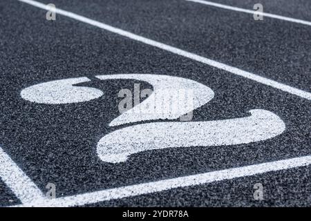 Fermez la voie numéro 2 sur une nouvelle piste de course noire avec des lignes de voie blanches et d'autres marquages. Banque D'Images