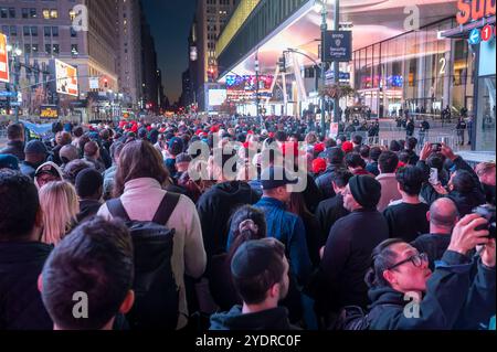 New York, États-Unis. 27 octobre 2024. NEW YORK, NEW YORK - OCTOBRE 27 : les partisans du candidat républicain à la présidence, l'ancien président américain Donald Trump, regardent la campagne se rassembler sur un grand écran à l'extérieur de Madison Square Garden le 27 octobre 2024 à New York. Crédit : Ron Adar/Alamy Live News Banque D'Images