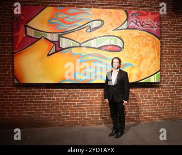 Los Angeles, Californie, États-Unis. 24 octobre 2024. Le conservateur/galeriste se tient à côté de l'œuvre d'art de Risk Rock à l'exposition d'art de Risk Rock - célébrant les 30 ans de Graffiti by Risk à l'Agora Gallery de Los Angeles, en Californie. Crédit : Sheri Determan Banque D'Images