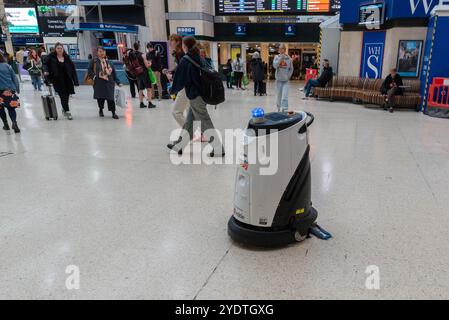 « Robot » de nettoyage automatique fonctionnant à l'intérieur de la gare ferroviaire de Charing Cross, Londres, Royaume-Uni. Épurateur de sol autonome ICE Cobotics en fonctionnement Banque D'Images