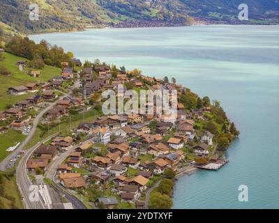 Village vallonné avec des maisons et des rues sur le bord d'un lac, entouré de montagnes, le lac de Brienz. Suisse Banque D'Images