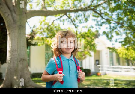 Enfant avec sacs à dos debout dans le parc près de l'école. Élèves avec des livres et des sacs à dos à l'extérieur. Concept d'éducation des enfants. Banque D'Images