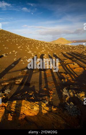 Ombres humaines sur la formation de lave et les formes rocheuses sur l'île de Bartolome dans les îles Galapagos, site du patrimoine mondial de l'UNESCO, Équateur Banque D'Images