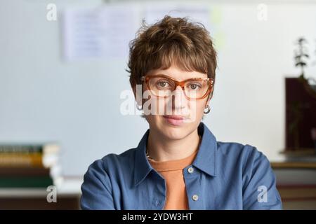 Portrait de jeune femme caucasienne portant des lunettes et chemise bleue Banque D'Images