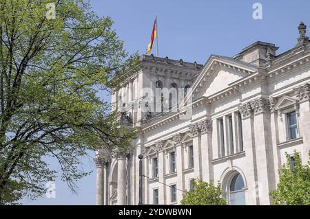 Vue partielle du bâtiment du Reichstag avec drapeau allemand et arbres, Berlin, Allemagne, Europe Banque D'Images