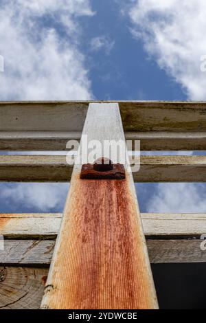 Boulon rouillé et support de pilier endommagé contre le ciel bleu Banque D'Images
