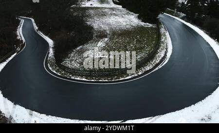 Virage en épingle à cheveux sur une route de campagne dans les montagnes de la région hivernale de l'Eifel Banque D'Images