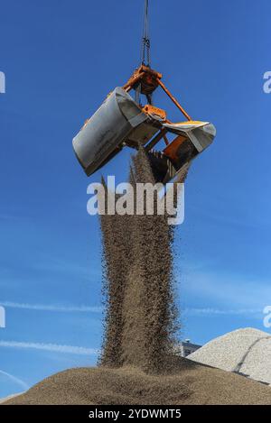 La grue à grue remplit le sable sur une colline Banque D'Images