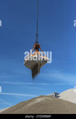 La grue à grue remplit le sable sur une colline Banque D'Images