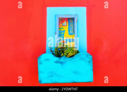 Gros plan d'une boîte à fleurs colorée et d'un volet de fenêtre peint sur une maison, Santorin, Grèce Banque D'Images