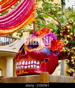 Crâne en papier géant mâché peint sur une immense chaise pour Halloween ou Day of the Dead dehors dans le centre commercial Las Rozas Village Madrid Espagne Banque D'Images