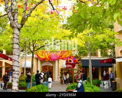 Crâne en papier géant mâché peint sur une immense chaise pour Halloween ou Day of the Dead dehors dans le centre commercial Las Rozas Village Madrid Espagne Banque D'Images