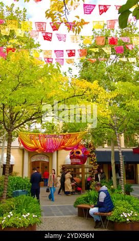 Crâne en papier géant mâché peint sur une immense chaise pour Halloween ou Day of the Dead dehors dans le centre commercial Las Rozas Village Madrid Espagne Banque D'Images