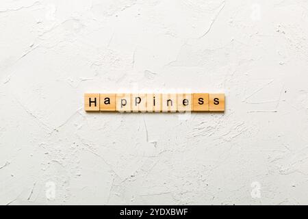 Le bonheur mot écrit sur une cale en bois. Le bonheur texte sur table, concept. Banque D'Images