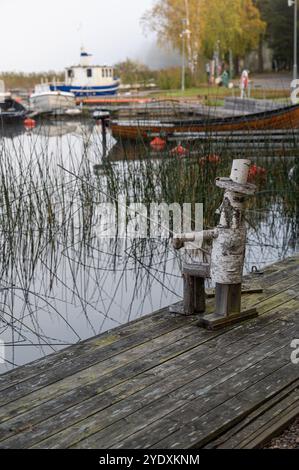 Littel homme en bois fait à la main assis sur la pêche à la jetée Banque D'Images