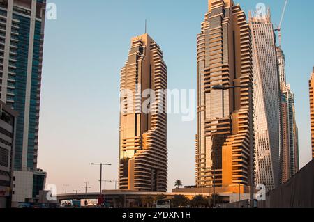 Dubaï, Émirats arabes Unis - 17 octobre 2016 : gratte-ciel modernes reflétant le coucher du soleil dans le paysage urbain animé. Banque D'Images