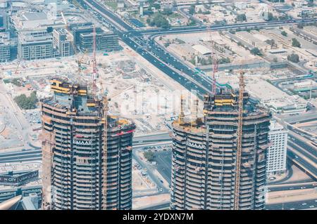 Dubaï, Émirats arabes Unis - 17 octobre 2016 : deux gratte-ciel en construction avec grues et paysage urbain en arrière-plan. Banque D'Images