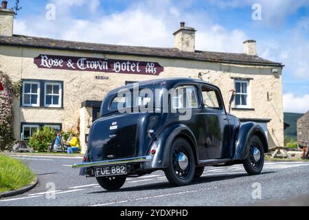 Voitures dans le rallye de voitures anciennes Beamish Relability 2024 passant devant le Rose and Crown Hotel à Bainbridge, Yorkshire Dales, Royaume-Uni. Banque D'Images