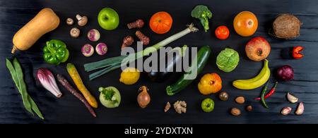 Plan panoramique de fruits et légumes frais déposés en vrac sur une table en bois noir. Vue de dessus fruits et légumes biologiques 016357 064 Banque D'Images