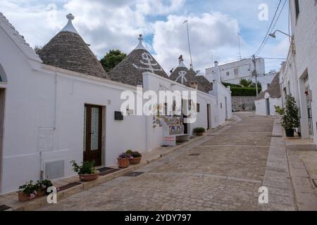 Alberobello Italie 18 septembre 2024 alors que le crépuscule descend, les maisons trulli uniques se dressent élégamment le long de la rue pavée des Pouilles. Banque D'Images