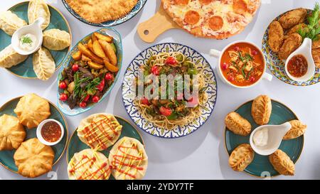 Plats asiatiques - lagman, manti, viande avec pommes de terre, soupe, belyashi sur fond blanc vue de dessus Banque D'Images