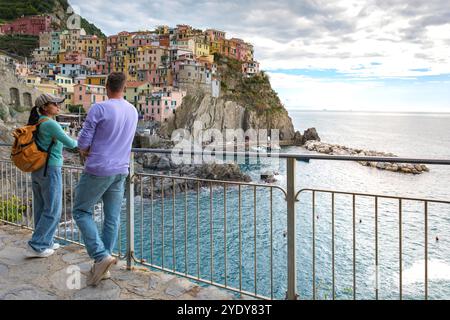 Les visiteurs contemplent les eaux scintillantes des Cinque Terre, admirant les charmants villages perchés sur les falaises, baignés par une douce lumière de l'après-midi. Manar Banque D'Images