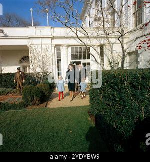 L'ancienne première dame des États-Unis, Jacqueline Kennedy, et ses enfants, Caroline Kennedy et John F. Kennedy, Jr., quittant la Maison Blanche à travers la roseraie pour la dernière fois avec l'assistant spécial du président américain John F. Kennedy, Dave Powers, derrière, Washington, D.C. USA, Cecil Stoughton, photographies de la Maison Blanche, 6 décembre 1963 Banque D'Images