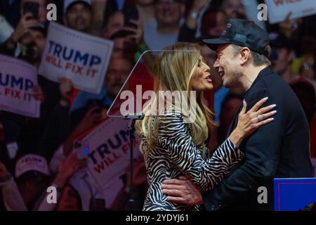 New York, États-Unis. 27 octobre 2024. Elon Musk embrasse Melania Trump alors qu'il la présente à un rassemblement Trump dimanche à New York. Les partisans de Trump chantent devant les médias à l’extérieur de Madison Square Garden avant le rassemblement en soutien à l’ancien président Donald Trump. Crédit : SOPA images Limited/Alamy Live News Banque D'Images