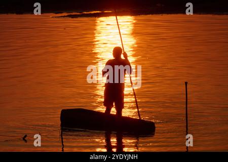 Pêcheur en canot de dugout sur la rivière Luangwa au coucher du soleil, South Luangwa National Park, Mfuwe, Zambie, Afrique Banque D'Images