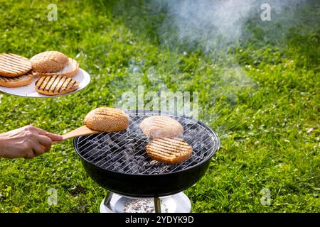 hamburger pain pain griller sur le barbecue au charbon de bois dans le jardin, mise au point sélective Banque D'Images