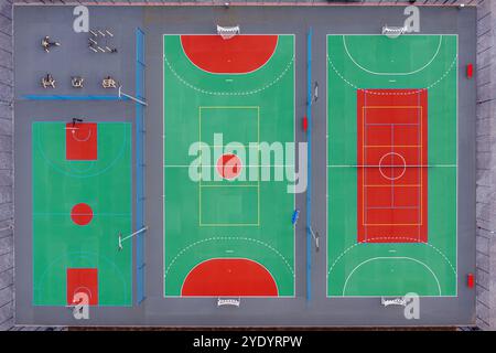 Les terrains colorés comprennent des terrains de basket-ball et de tennis, mettant en valeur un environnement urbain actif. Banque D'Images
