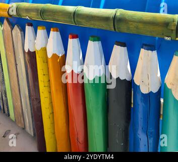 Fragment d'une clôture avec une clôture de piquet sous la forme de crayons multicolores Banque D'Images