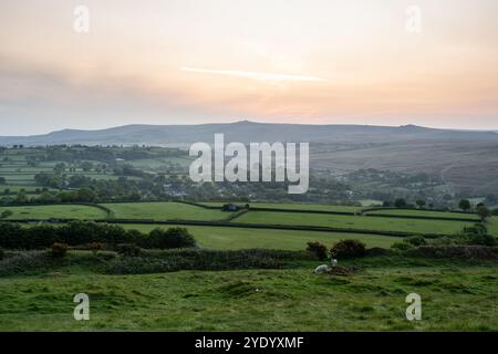 La lumière de l'aube tombe sur les Tors de Dartmoor au-dessus des villages de North Brentor et Lydford vus de la colline de Brent Tor. Banque D'Images