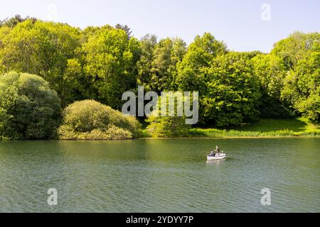 Les pêcheurs pêchent à partir d'un bateau à rames sur le réservoir Hawkridge dans le Somerset. Banque D'Images