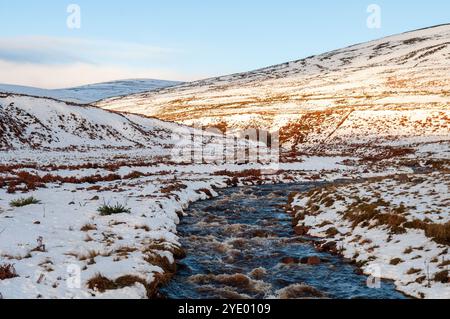 La neige se trouve sur les champs et les montagnes le long de la rivière Helmsdale dans la vallée de Kildonan Strath à Sutherland dans l'extrême nord des Highlands d'Écosse. Banque D'Images