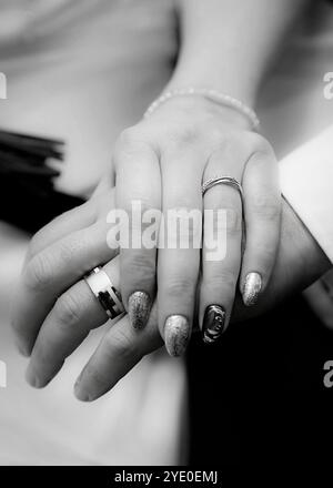 Gros plan des mains de mariée et de marié montrant des anneaux de mariage. Banque D'Images